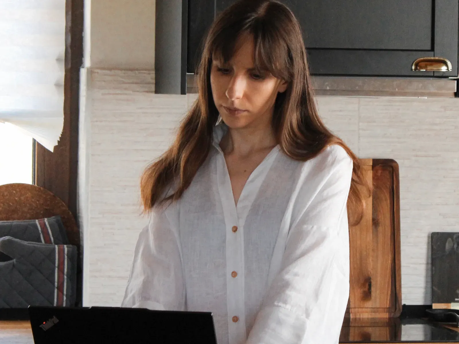 Jelena working on a laptop at her kitchen counter